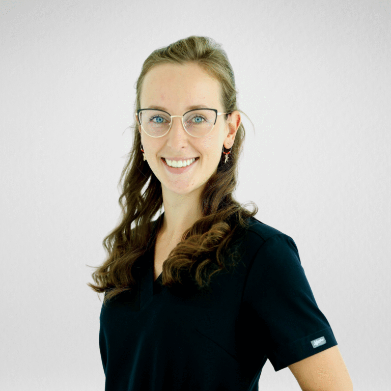 Uśmiechnięta Lekarz stomatolog dr Daria Kasprowicz w czarnym fartuchu